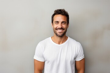 Fototapeta premium Portrait of a merry man in his 30s smiling at the camera on minimalist or empty room background