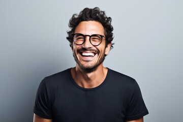 Fototapeta premium Portrait of a grinning man in his 30s laughing in minimalist or empty room background