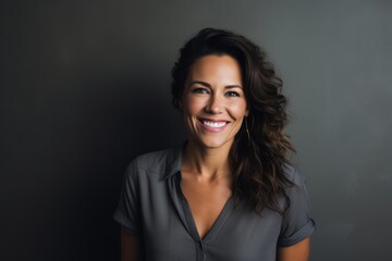 Fototapeta premium Portrait of a glad woman in her 40s smiling at the camera isolated on minimalist or empty room background