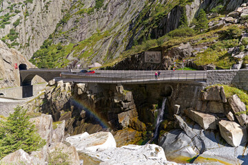 Scenic view of famous Devil's Bridge at Schöllenen Gorge with Reuss River and rainbow on a sunny...