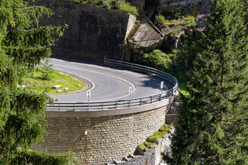 Serpentine mountain pass road at famous Schöllenen Gorge at Swiss mountain village Göschenen on a sunny late summer day. Photo taken September 19th, 2023, Göschenen, Canton Uri, Switzerland.
