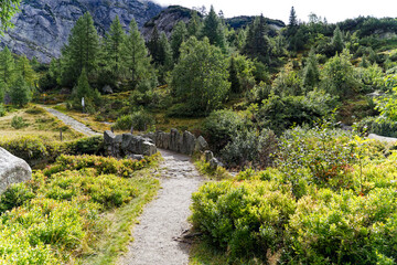 Scenic view of alpine landscape at hiking trail with stone bridge at Swiss mountain pass Grimsel on a cloudy late summer day. Photo taken September 19th, 2023, Grimsel, Canton Bern, Switzerland.