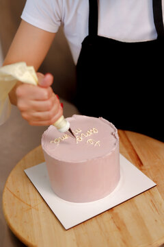 Decorating a cake with elegant icing and text