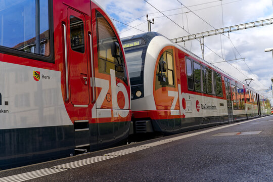 Frog perspective of red and white train of Swiss Central Railway at railway station of Meiringen on a sunny late summer day. Photo taken September 19th, 2023, Meiringen, Canton Bern, Switzerland.