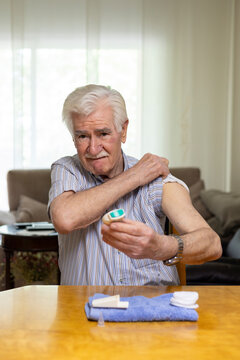 Elderly man monitoring blood sugar levels at home