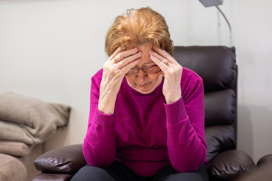 Elderly woman experiencing hypoglycemia symptoms at home