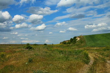 Obraz premium A grassy hill with a blue sky