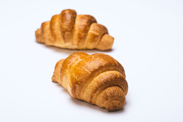 two fresh croissants on white background