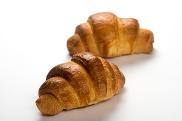 two fresh croissants on white background