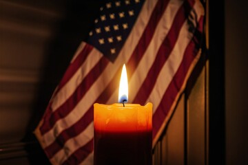 Mourning candle on the background of the American flag. Memorial day concept.
