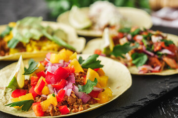 set of delicious fresh colorful tacos on a dark background