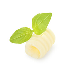 One tasty butter curl and basil leaves isolated on white