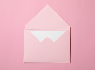 Letter envelope with card on pink background, top view