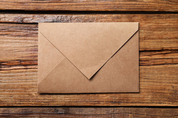 Letter envelope on wooden table, top view