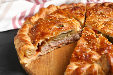 Cut delicious homemade pie on black table, closeup