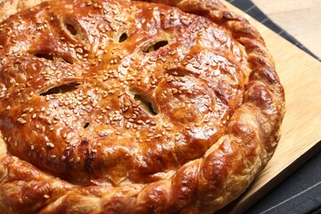 Tasty homemade pie with filling on wooden table, closeup