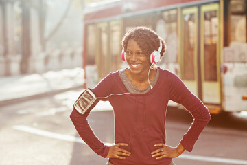 Young African American woman jogging with headphones in the city