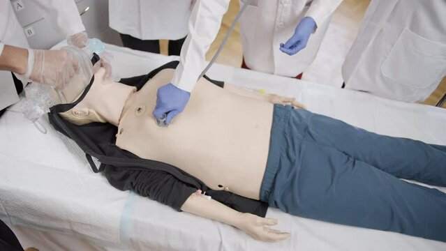 First aid training. Oxygen mask on the doll's face. A doctor listens to the patient's lungs