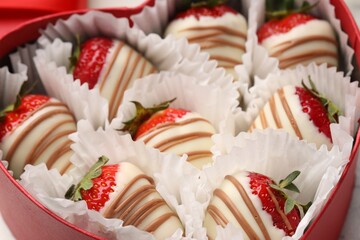 Delicious chocolate covered strawberries in heart shaped box, closeup