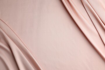 Crumpled pink silk fabric as background, top view. Space for text