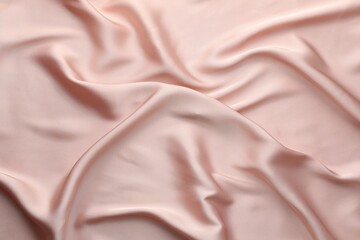 Crumpled pink silk fabric as background, top view