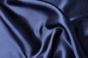 Crumpled dark blue silk fabric as background, closeup