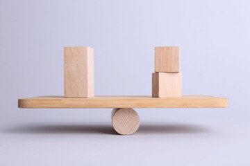 Equality concept. Seesaw scale with wooden blocks on light background
