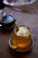 A glads of ginger honey tea with apple garnish on top