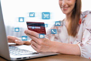 Elegant customer wearing floral shirt holding credit card choose online platform. Smart consumer...