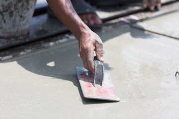 Construction worker plastering wet concrete at precast concrete wall construction site. Worker or...