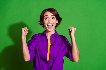 Photo of funny young woman in purple stylish shirt and brown bob haircut celebrate her promotion at...
