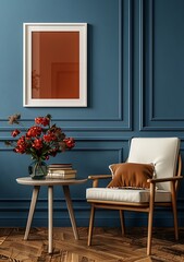 A blue wall with an empty white photo frame, next to it is an armchair and table on which there will be books and flowers in pots