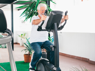 People sport concept. Happy senior man cycling doing exercises to stay fit. Elderly bearded man...