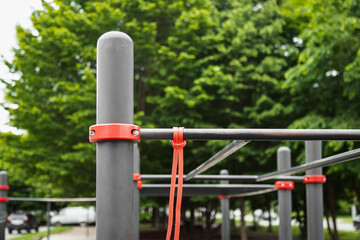 Elastic rubber band for exercise tied on a horizontal bar . Outdoor gym concept