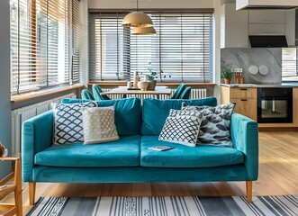 Beautiful interior of a modern living room with a teal sofa and dining table, a home office seen in the background