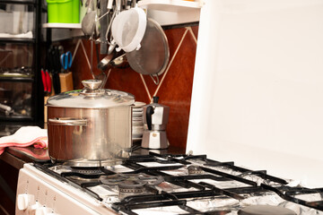 A white stove top with a pot on it. The pot is filled with water and is boiling