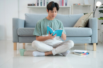 Young man enjoying a book in a modern living room