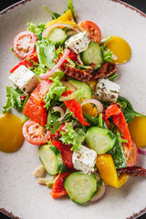 salad with baked bell peppers tomatoes cucumber red onion and feta cheese