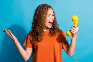 Portrait photo of funny young red hair girl using vintage telephone angry talking with opponent...