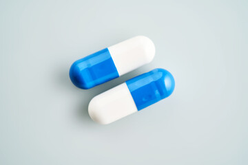 Blue and white capsules on a blue background.