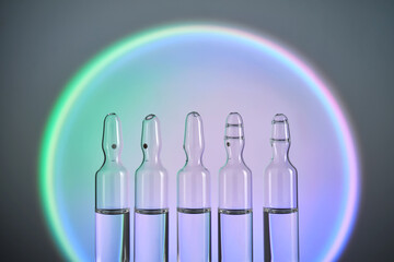 Several ampoules for injection with medicines on a blue background.