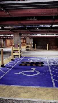 An empty parking garage with a prominent handicapped parking space visible, highlighting accessibility features.