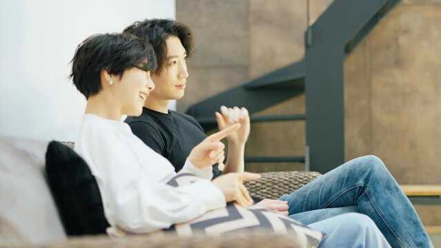 リビングのソファでくつろぐカップル