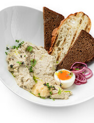 Delicious meat pate with mushrooms, egg, grilled toast and onions rings on plate isolated on white background. Appetizers and snacks, close up, top view