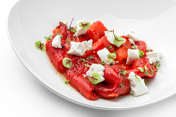 Baked roasted red pepper with feta cheese on plate isolated on white background. Healthy food, vegan salad, close up, top view