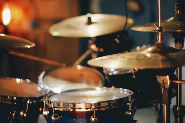 Fototapeta premium A close up of a drum kit with a bright yellow cymbal. The drum kit is surrounded by a dark background