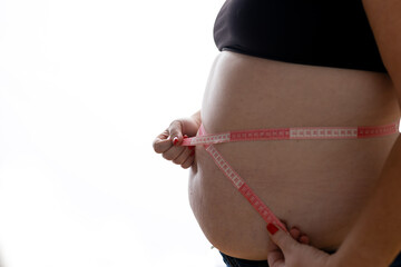Overweight Women stressing over fat belly, using measuring tape. Fat woman with tape measure