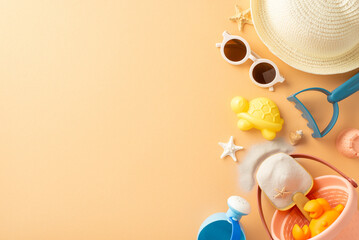 Sunny getaway for kids: top view of sand playset, stylish sunhat, shades, seashells, starfish on a...