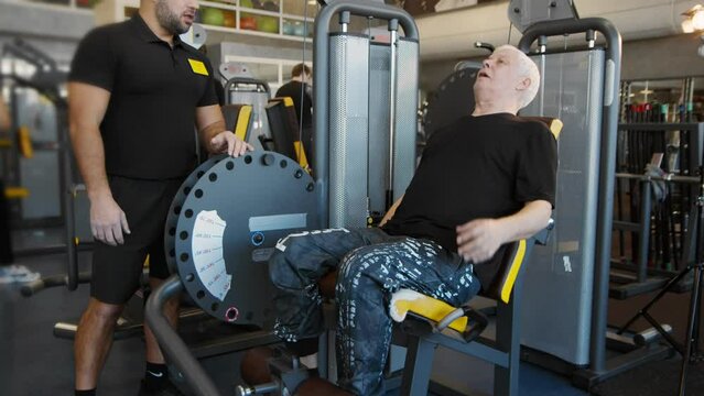 An elderly man is working out in the gym