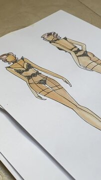 Woman looking at sketches of underwear. Vertical video. 
